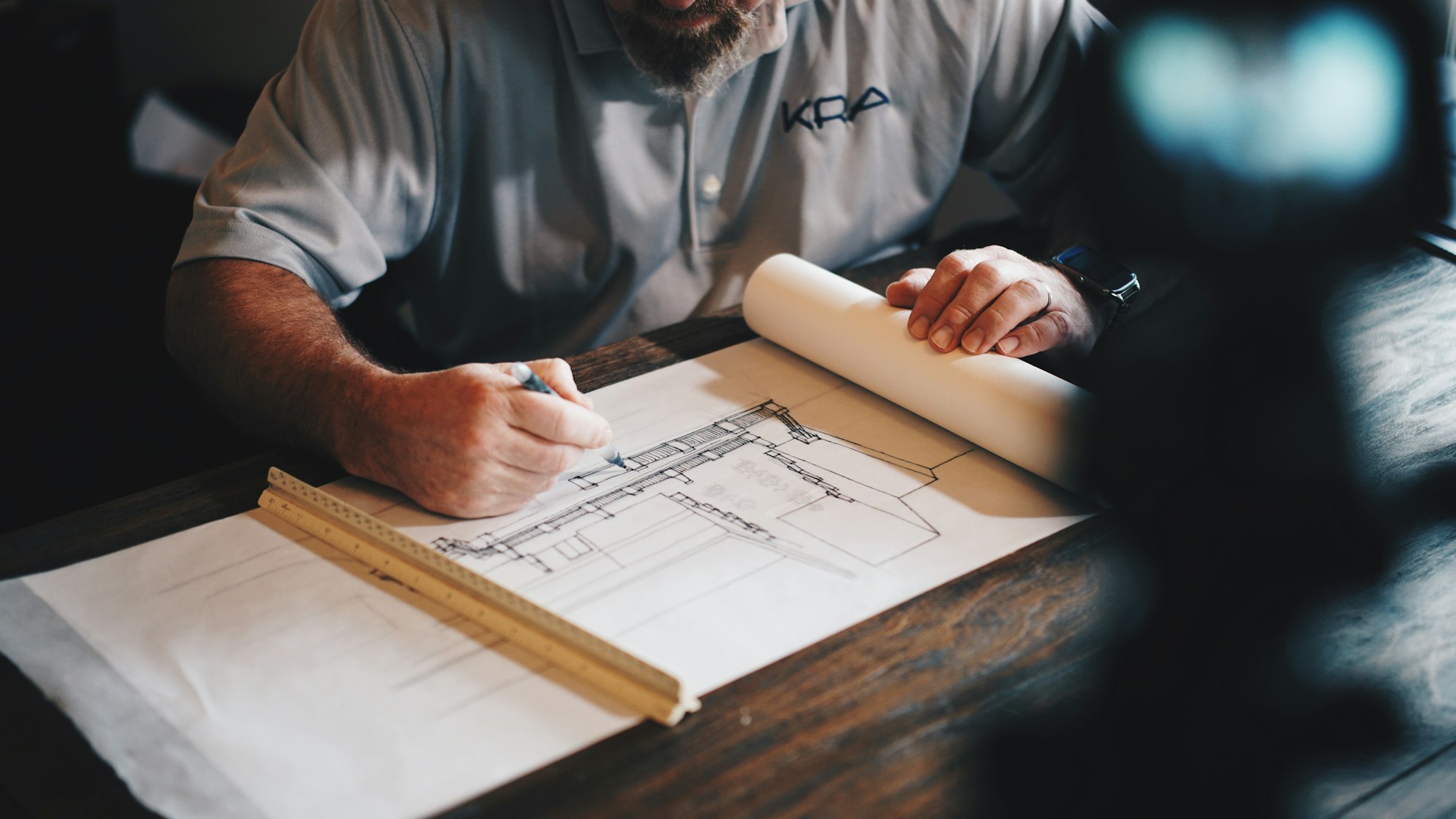 A contractor marking up construction drawings at a desk